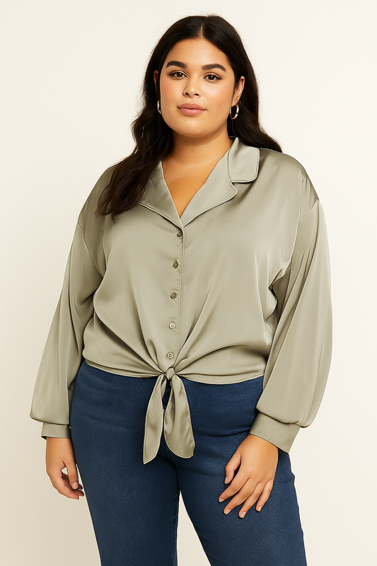 Woman wearing a light green blouse with long sleeves and blue pants on a beige background